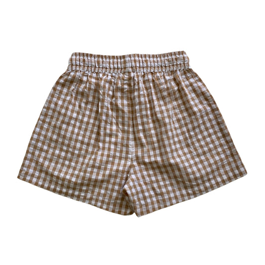 Brown and white checkered shorts on a white background. Seersucker gingham shorts.