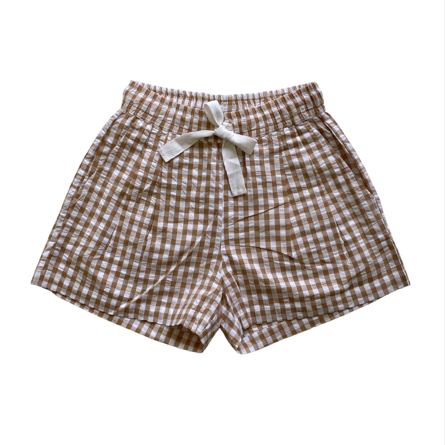 Brown and white checkered shorts with a bow on a white background. Seersucker gingham elasticated shorts with twill tie. Organic Cotton Fabric.