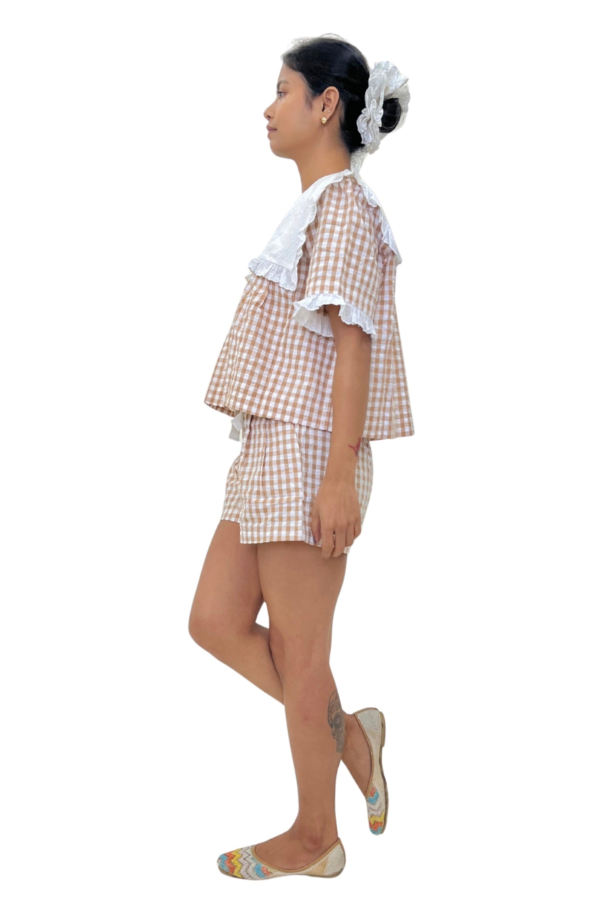 Woman wearing a checkered gingham set on a white background