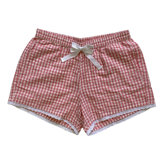 Pink and white checkered shorts with a bow on a white background