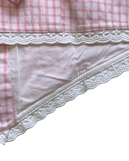 Close-up of a pink and white checkered waistcoat with lace trim and lining on a white background