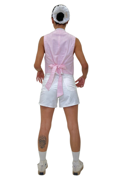 Person wearing a pink checkered waistcoat and white shorts on a white background