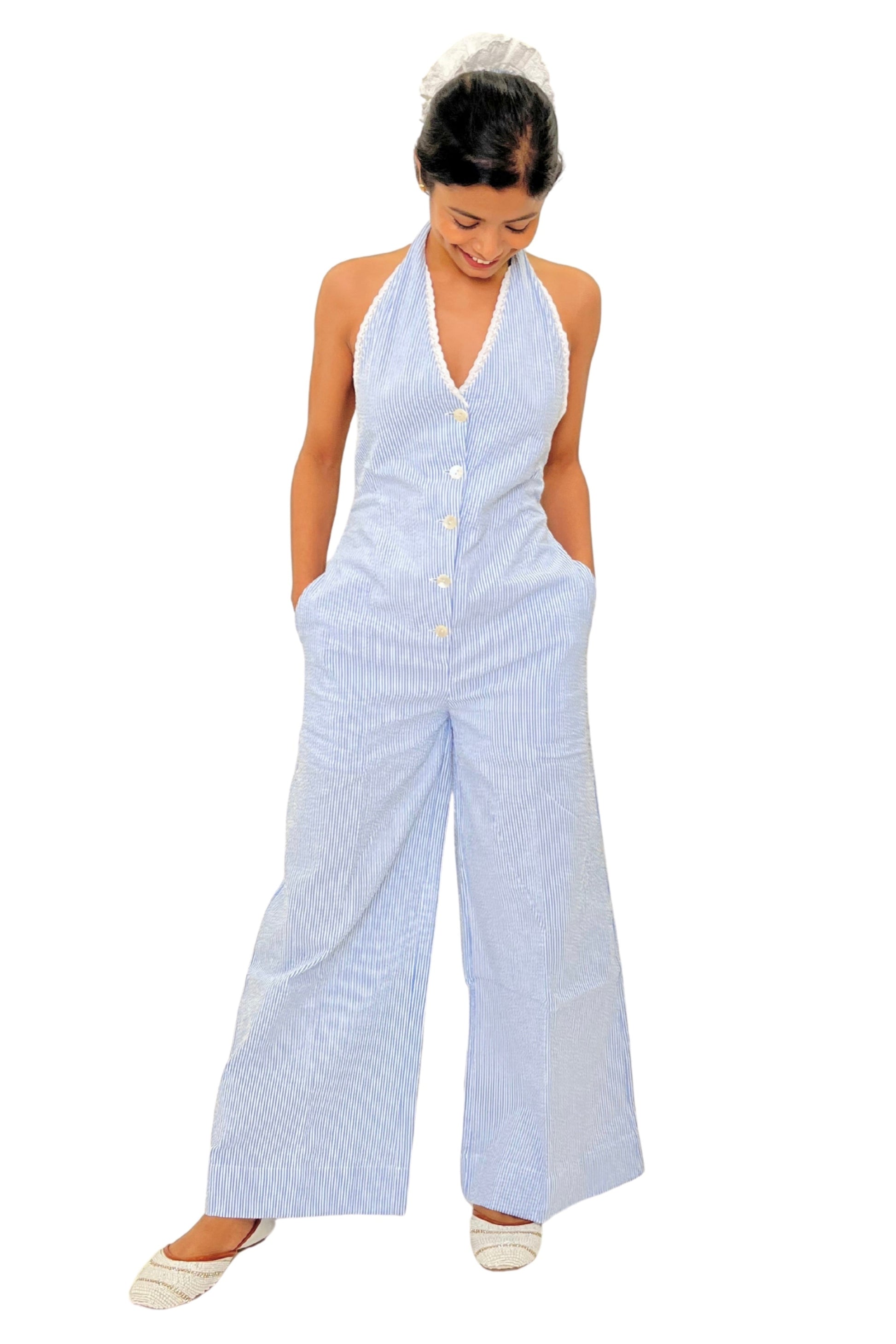 Woman wearing a light blue striped jumpsuit on a white background