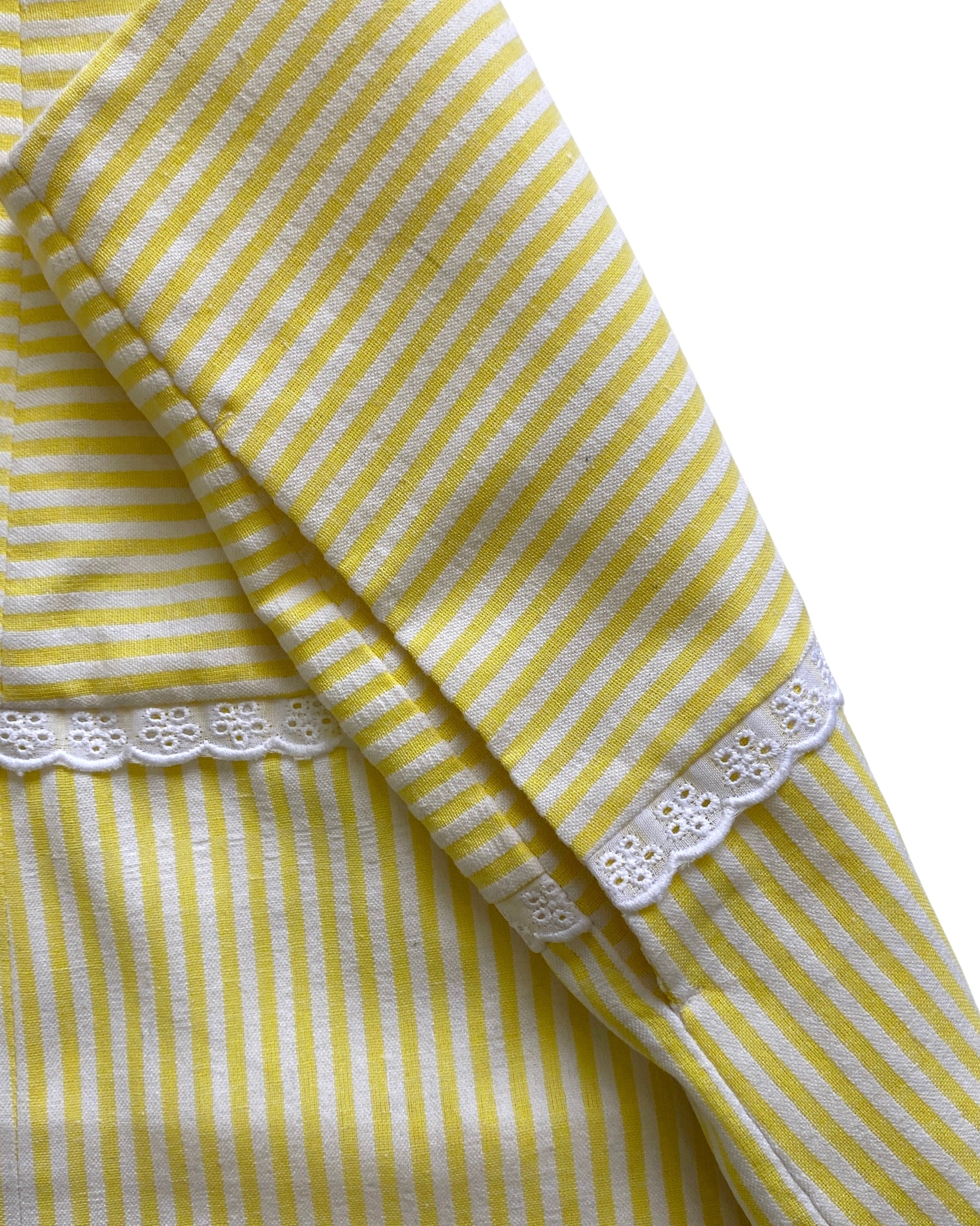 Yellow and white striped skirt with lace trim on a white background